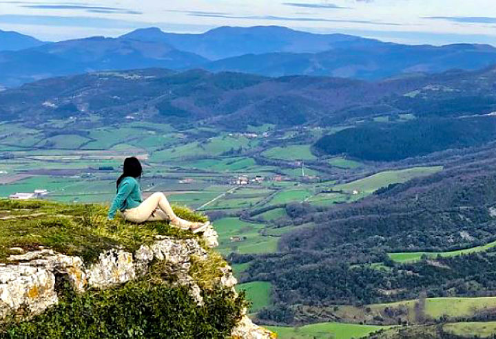 Study Abroad student looks out over valley from cliff