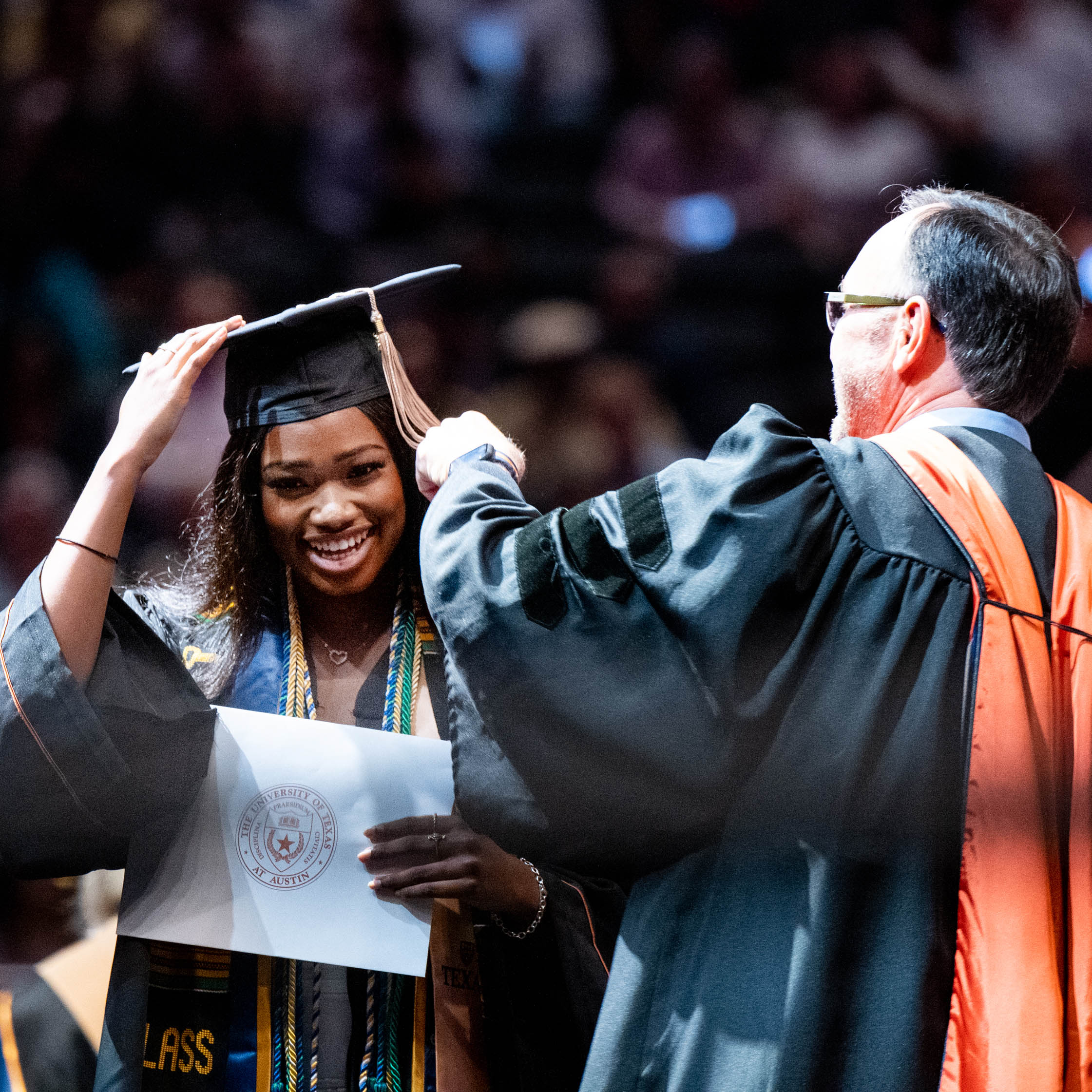 A dean turns a graduate's tassle during the McCombs BBA Commencement ceremony