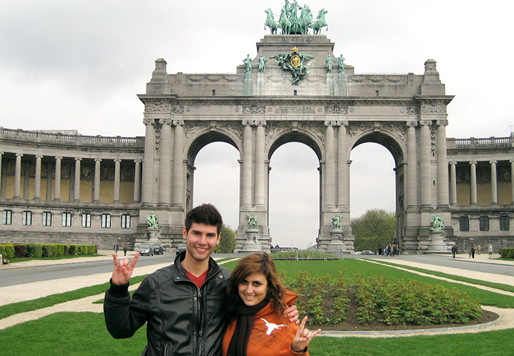 Two smiling students give hook em horns in Belgium